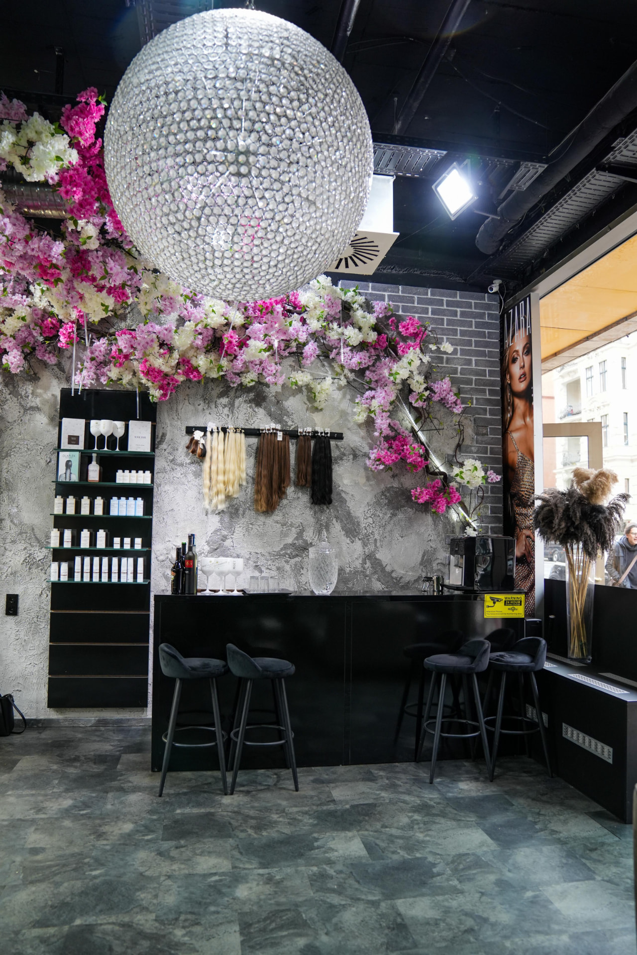 Empfangstheke mit Kristall-Kronleuchter und Blüten im AZARA Salon